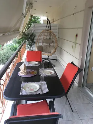 a black table and red chairs on a balcony at SECOND FLOOR Best stay in Athens