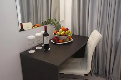 a table with a bowl of fruit and a bottle of wine at International Atene hotel in Athens