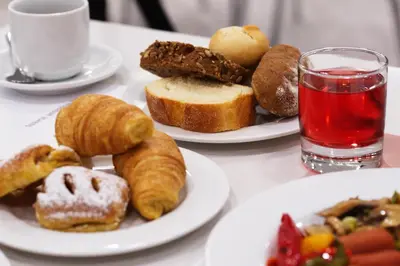 a table with two plates of pastries and a glass of water at International Atene hotel in Athens
