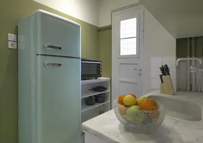 a kitchen with a bowl of fruit and a refrigerator at New Hidden Gem, A Studio at a Super Prime Location in Athens