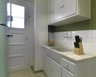 a kitchen with white cabinets and a sink and a window at New Hidden Gem, A Studio at a Super Prime Location in Athens