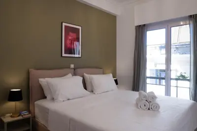 a bedroom with a white bed with towels on it at Rare 1BR APT, next to the new Goulandris Museum in Athens