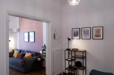 a living room with a blue couch and a pink wall at Rare 1BR APT, next to the new Goulandris Museum in Athens