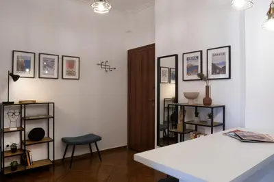 a room with a table and a chair and some pictures at Rare 1BR APT, next to the new Goulandris Museum in Athens