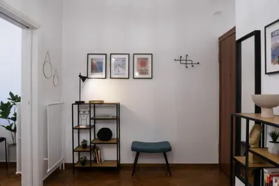 a living room with a chair and a white wall at Rare 1BR APT, next to the new Goulandris Museum in Athens