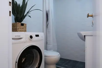 a bathroom with a washing machine and a toilet at Rare 1BR APT, next to the new Goulandris Museum in Athens