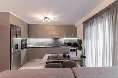 a kitchen with a table and chairs in a room at Niarchos Panorama Maisonette in Athens