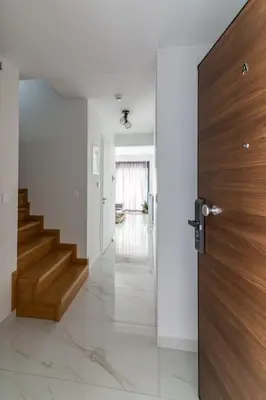 a hallway with a staircase and a wooden door at Niarchos Panorama Maisonette in Athens