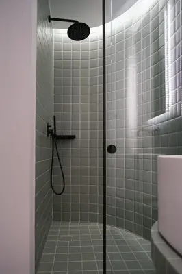 a bathroom with a shower with green tiles at K23 Color Suites in Athens