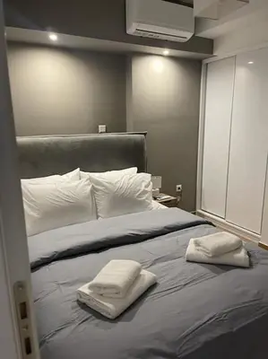 a bed with two towels sitting on top of it at Niarchos apartment III in Athens