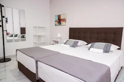 a bedroom with a large bed with white sheets at Lysandros Apartments in Athens, near the METRO in Athens