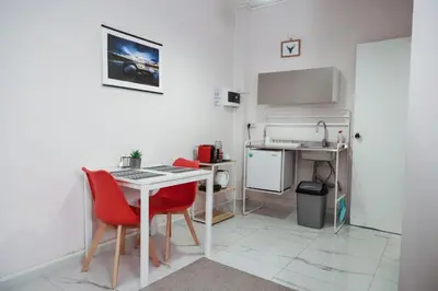 a small white room with a desk and red chairs at Lysandros Apartments in Athens, near the METRO in Athens