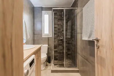 a bathroom with a shower and a toilet and a sink at Lovely seaside apartment next to Starbucks opposite the beach park of Flisvos in Athens