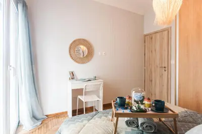 a room with a bed and a table and a desk at Lovely seaside apartment next to Starbucks opposite the beach park of Flisvos in Athens