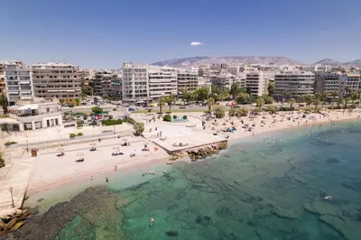 an aerial view of a beach with people in the water at Lovely seaside apartment next to Starbucks opposite the beach park of Flisvos in Athens