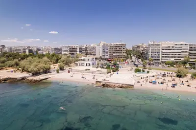 an aerial view of a beach with people in the water at Lovely seaside apartment next to Starbucks opposite the beach park of Flisvos in Athens