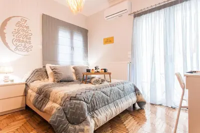 a bedroom with a bed with a table on it at Lovely seaside apartment next to Starbucks opposite the beach park of Flisvos in Athens