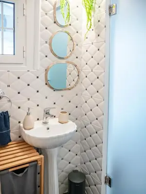 a bathroom with a sink and mirrors on the wall at The Arcade in Athens