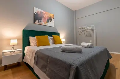a bedroom with a large bed with yellow pillows at Athenian center apartments in Athens