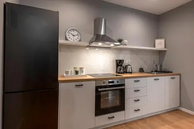 a kitchen with white cabinets and a black refrigerator at Athenian center apartments in Athens