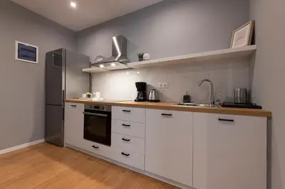 a kitchen with white cabinets and a stainless steel refrigerator at Athenian center apartments in Athens