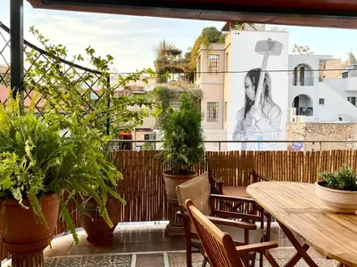 a patio with a wooden table and chairs and plants at Athenian Condo in Athens