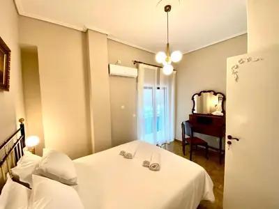 a bedroom with a bed and a mirror and a piano at Athenian Condo in Athens