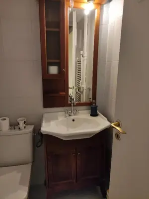 a bathroom with a sink and a toilet and a mirror at Seven Seconds Away Apartment in Athens