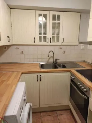 a kitchen with white cabinets and a sink at Seven Seconds Away Apartment in Athens