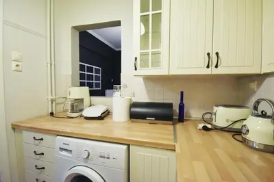 a kitchen with a counter top with a washing machine at Seven Seconds Away Apartment in Athens