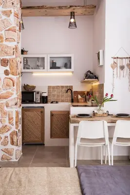 a kitchen with white cabinets and a table and chairs at Athena Luxury Studios in Athens