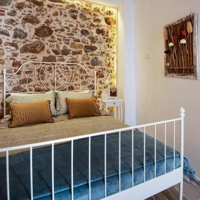 a bedroom with a bed with a stone wall at Athena Luxury Studios in Athens