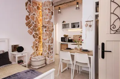 a kitchen and dining room with a stone wall at Athena Luxury Studios in Athens
