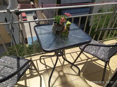 a glass table with a potted plant on a balcony at Acropolis Urban Flat in Athens