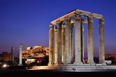 an ancient temple with columns in a city at night at Acropolis Urban Flat in Athens