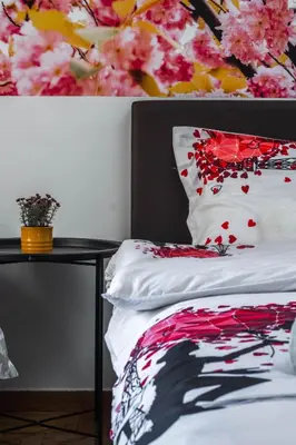a bedroom with a bed and a table with flowers at Acropolis Urban Flat in Athens