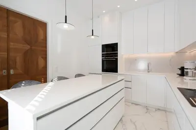 a white kitchen with white cabinets and marble floors at Upscale Athens Luxury Penthouse in Athens