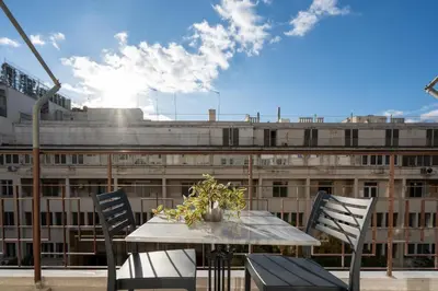 a table and chairs on a balcony with a large building at Upscale Athens Luxury Penthouse in Athens