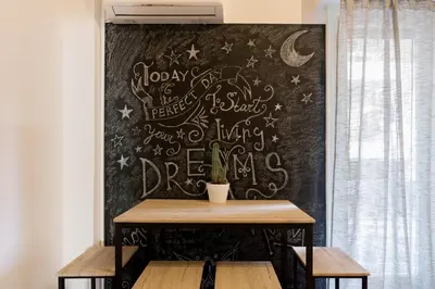 a wall with a table with writing on it at Cozy Apartment with Private Courtyard , Near Syngrou-Fix Metro Station in Athens