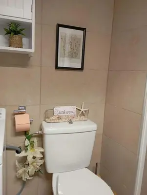 a bathroom with a white toilet with a sign on it at Cozy Apartment with Private Courtyard , Near Syngrou-Fix Metro Station in Athens