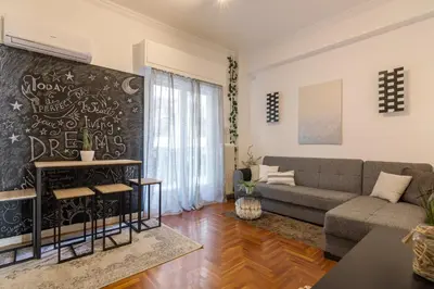 a living room with a couch and a chalkboard wall at Cozy Apartment with Private Courtyard , Near Syngrou-Fix Metro Station in Athens