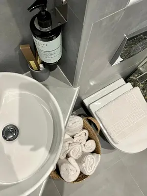 a bathroom counter with a sink and a basket of donuts at VJ Athens in Athens