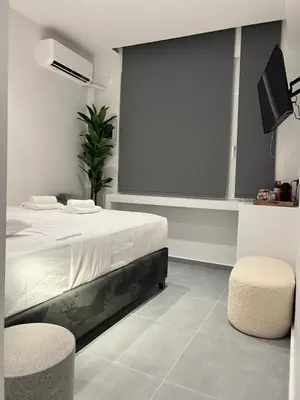 a bedroom with a bed and a tv and stool at VJ Athens in Athens
