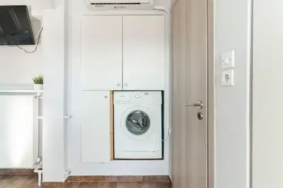 a white laundry room with a washer and dryer at Acropolis from my bed in Athens