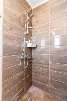 a bathroom with a shower with wooden walls at Acropolis from my bed in Athens