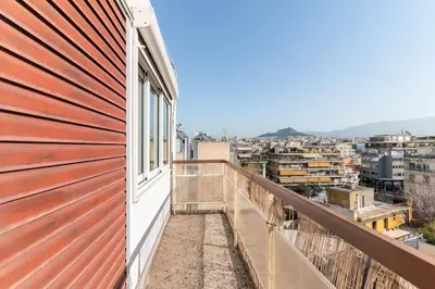 a balcony with a view of a city at Acropolis from my bed in Athens