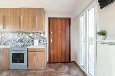 a kitchen with wooden cabinets and a wooden door at Acropolis from my bed in Athens