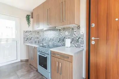 a kitchen with wooden cabinets and a stove top oven at Acropolis from my bed in Athens