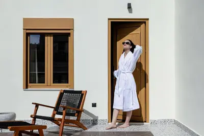 a woman in a white robe standing in front of a door at Athens Feeling in Athens