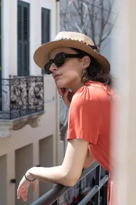 a woman wearing a hat and sunglasses leaning on a railing at Athens Feeling in Athens